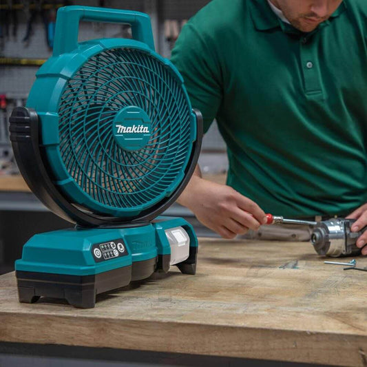 Person using a Makita fan in a workshop setting