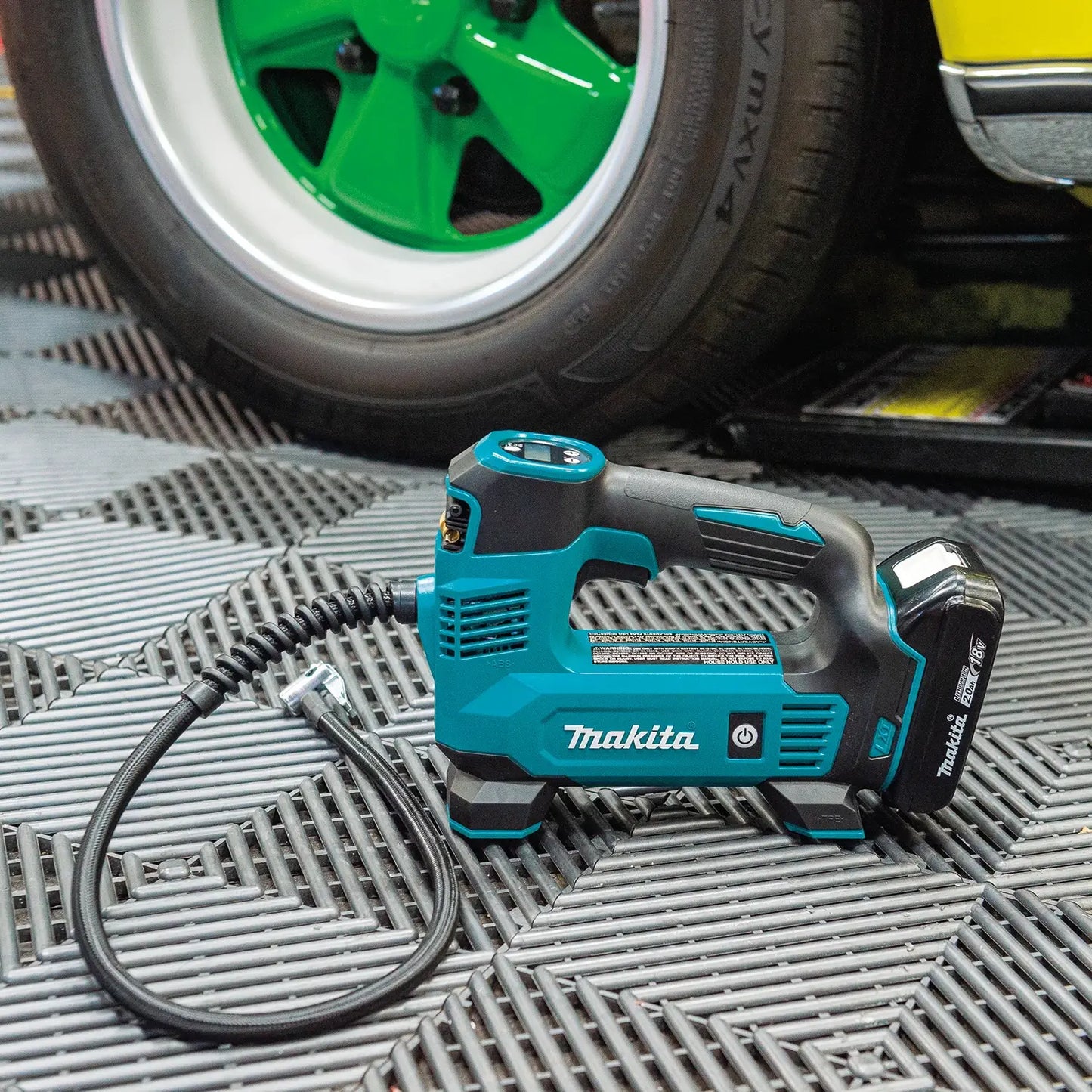 Makita power tool on a metal surface with a green wheel in the background