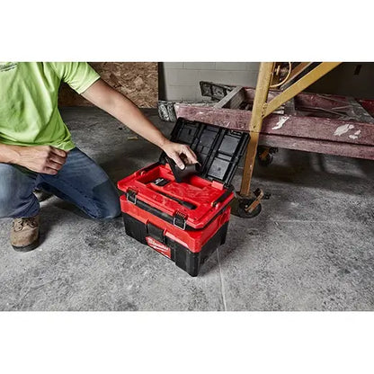 Person opening a red toolbox in a workshop setting