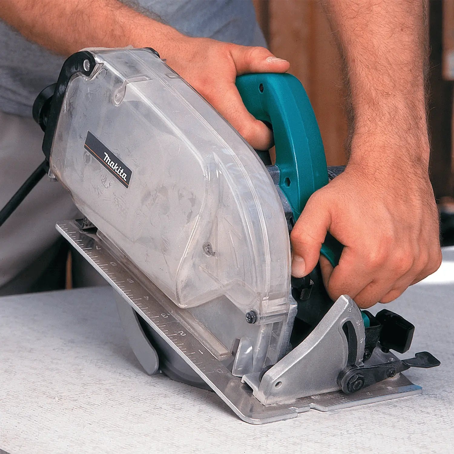 Person using a Makita circular saw on a concrete surface