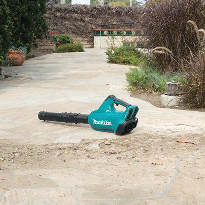Makita leaf blower on a stone patio with garden background