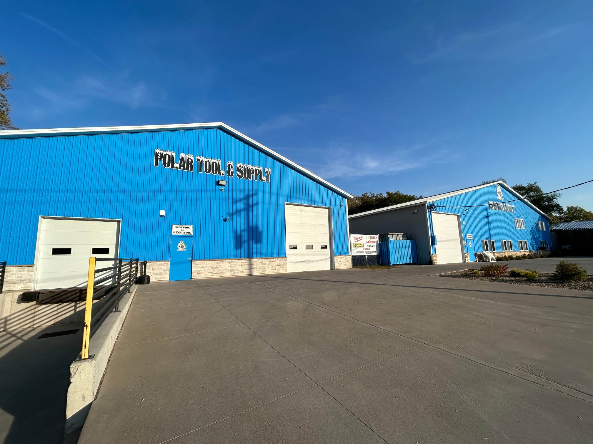 Blue warehouse building with 'Polar Tool & Supply' sign on a clear day