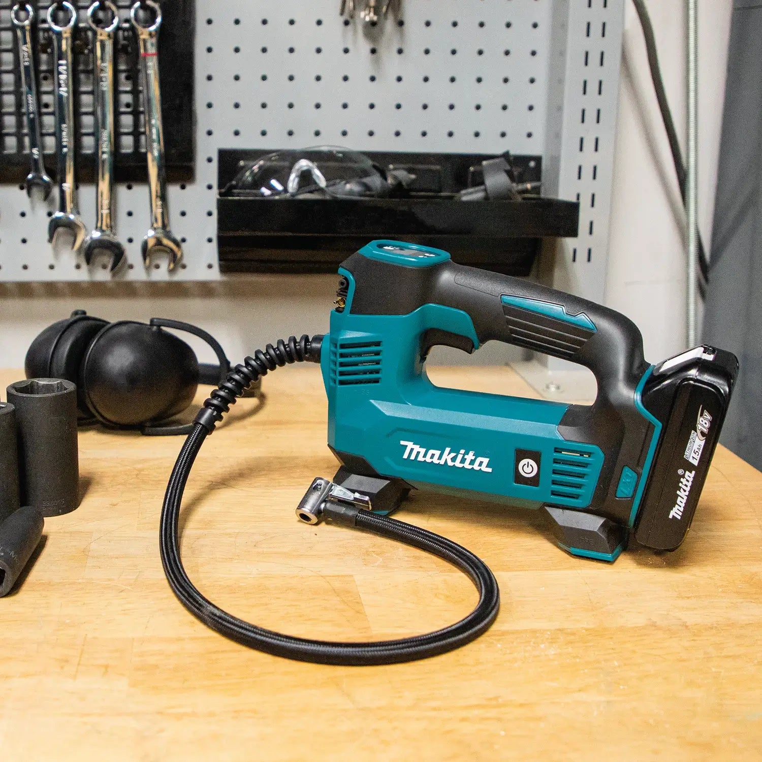 Makita power tool on a workbench with tools in the background