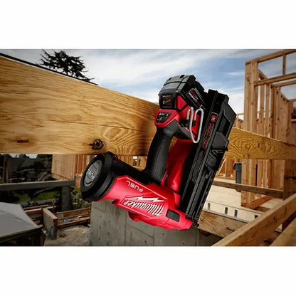 Red and black nail gun on a wooden beam with a construction site background