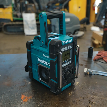 Makita radio on a workbench with construction equipment in the background