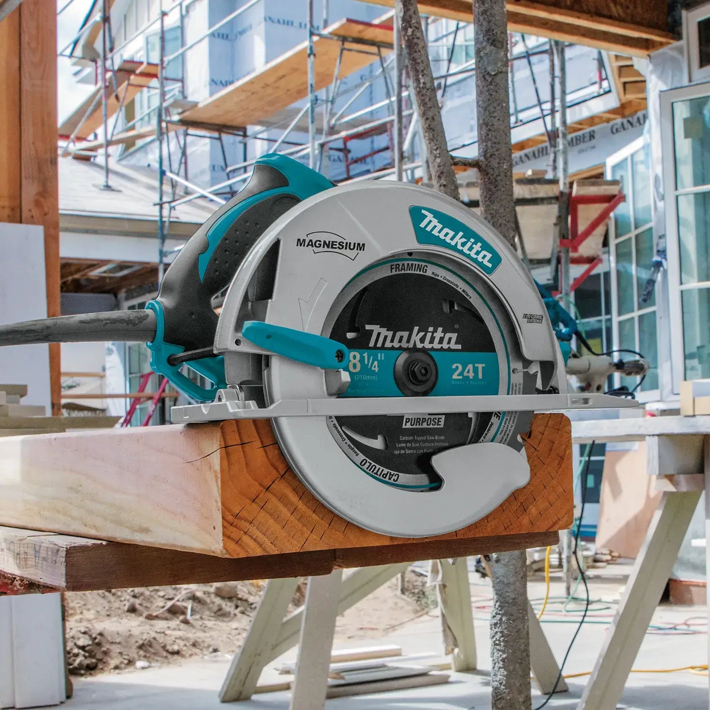 Makita circular saw cutting a piece of wood with a construction site in the background
