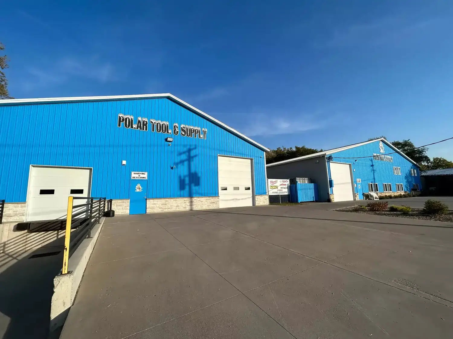 Blue warehouse building with 'Polar Tool & Supply' sign on a clear day