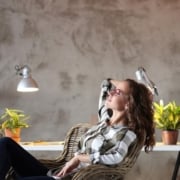 Image of a woman sitting back in her chair in front of a white desk