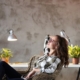 Image of a woman sitting back in her chair in front of a white desk